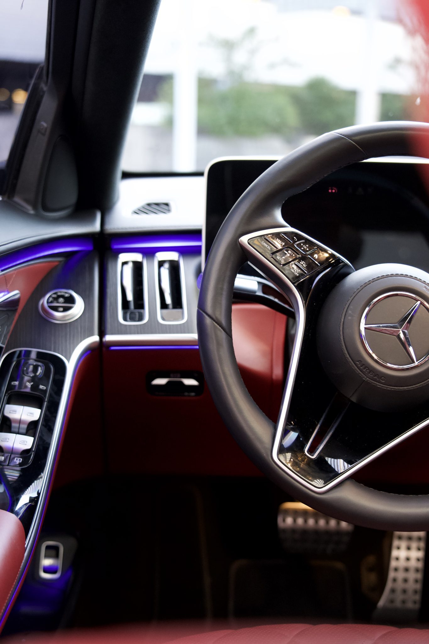 Close-up of the Mercedes-Benz S580 steering wheel, showcasing premium materials and advanced controls for Houston rentals.