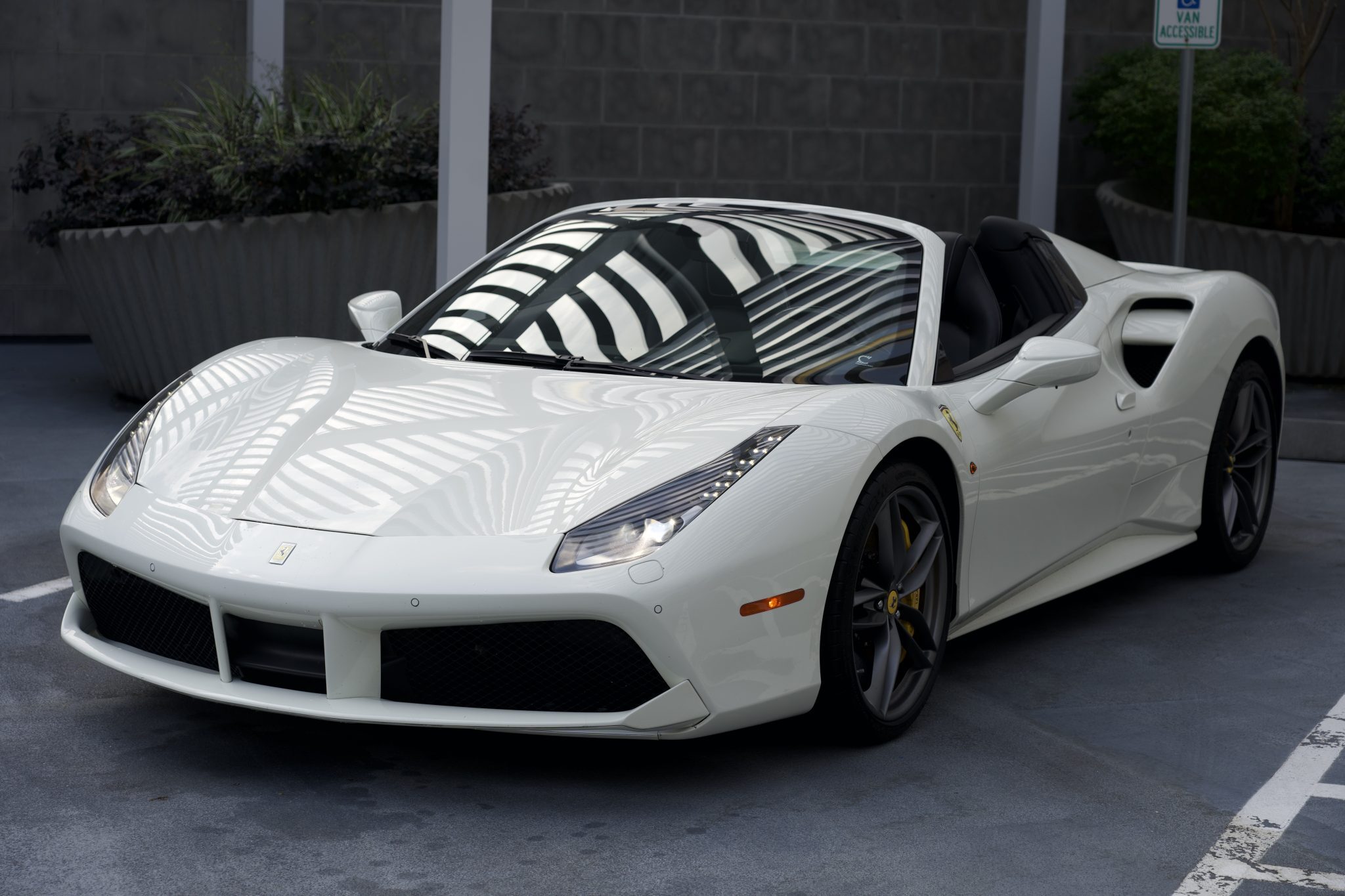Close-up of the Ferrari 488 Spider’s front design, highlighting its iconic headlights and aerodynamic features for Houston rentals.