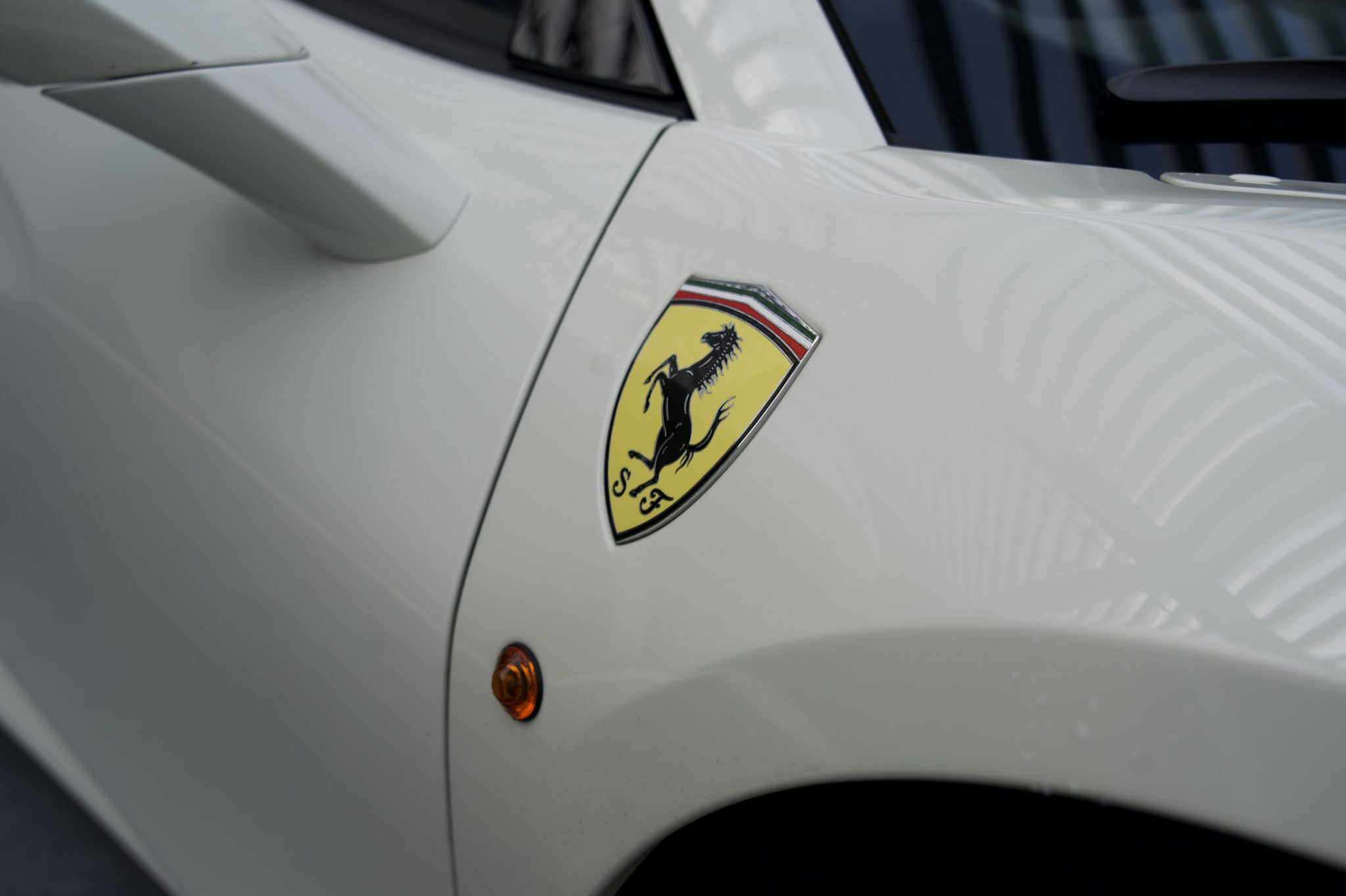 Close-up of the Ferrari badge on the 488 Spider, representing luxury and power for Houston exotic car rentals.