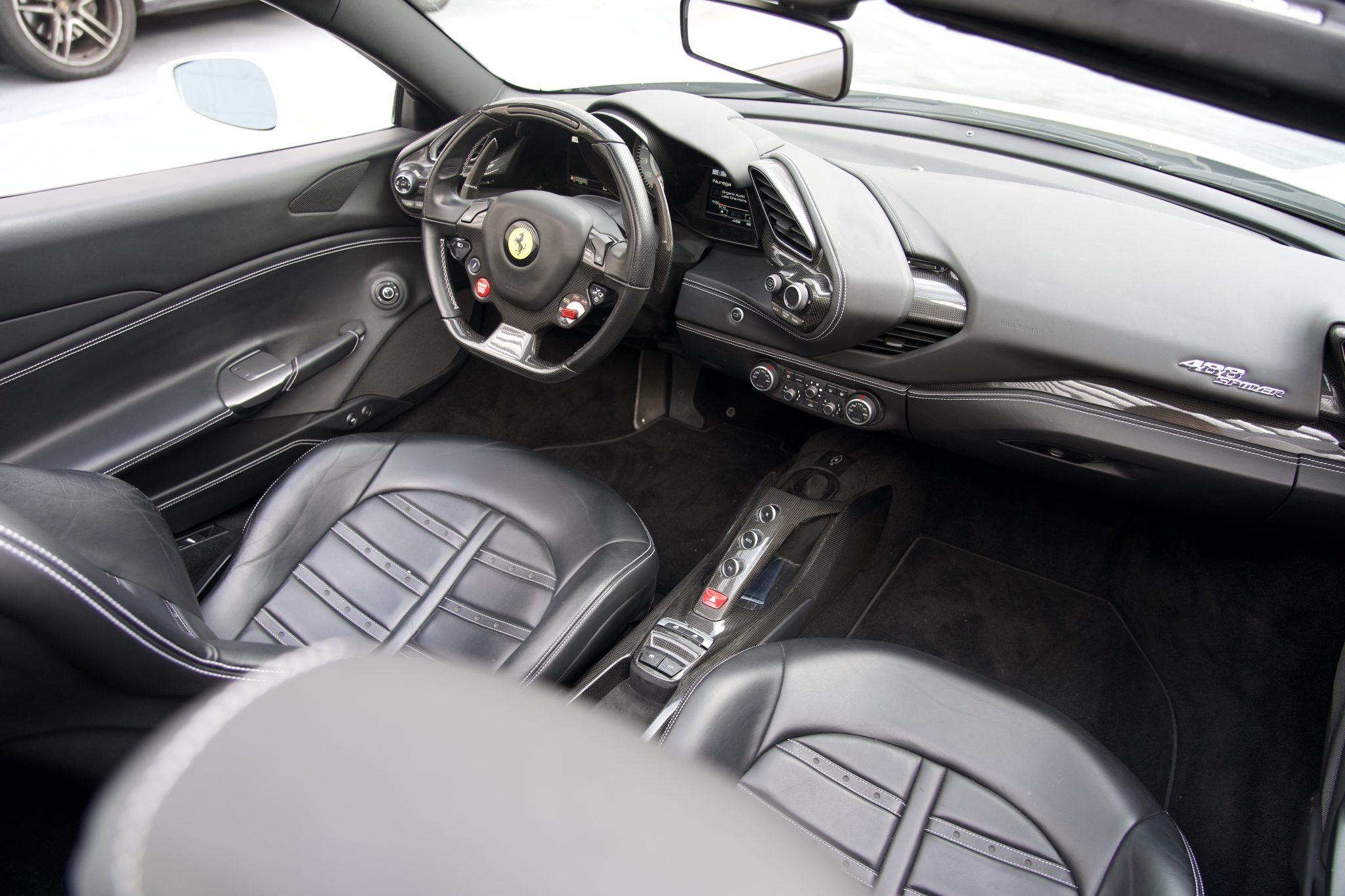 Interior of the Ferrari 488 Spider, showcasing premium leather seats and a state-of-the-art dashboard for Houston rentals.