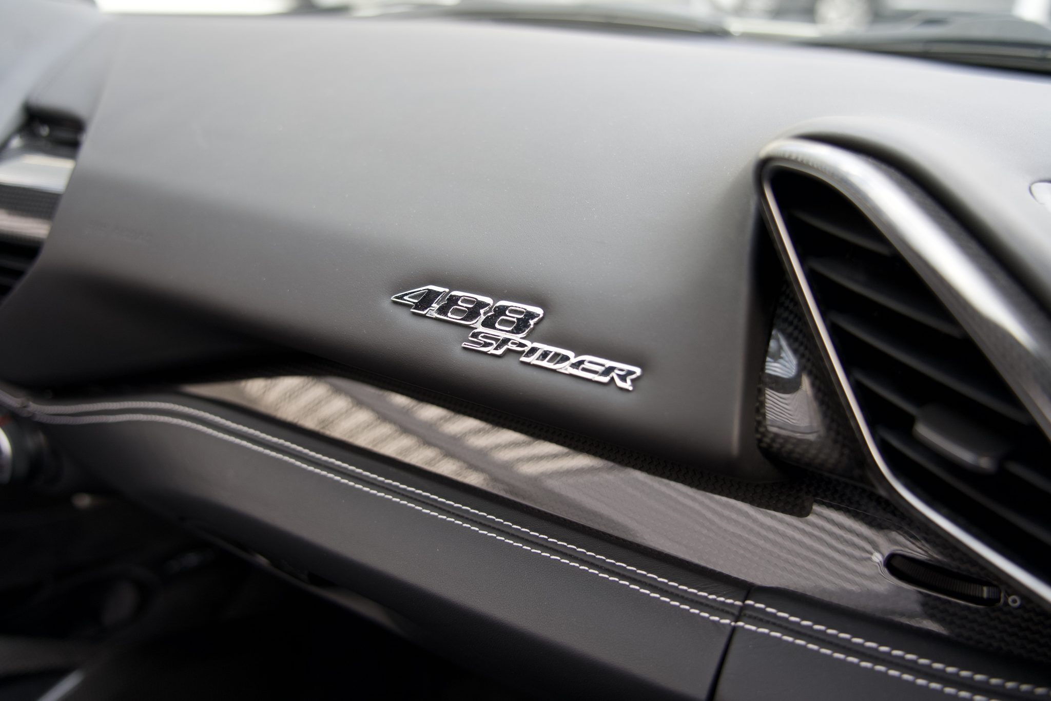 Close-up of the Ferrari 488 Spider dashboard, featuring advanced technology and sleek design for Houston rentals.