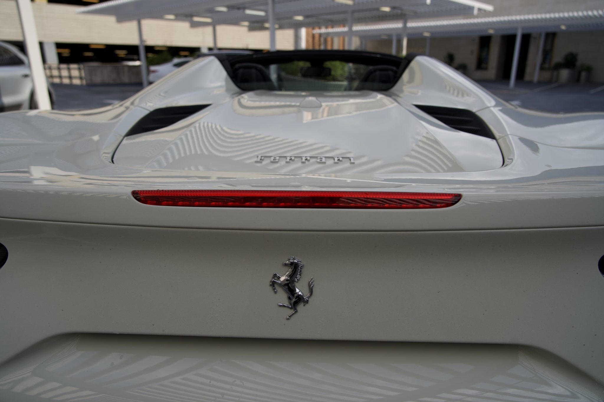 Rear design of the Ferrari 488 Spider, showcasing its sleek taillights and aerodynamic curves for rentals in Houston.