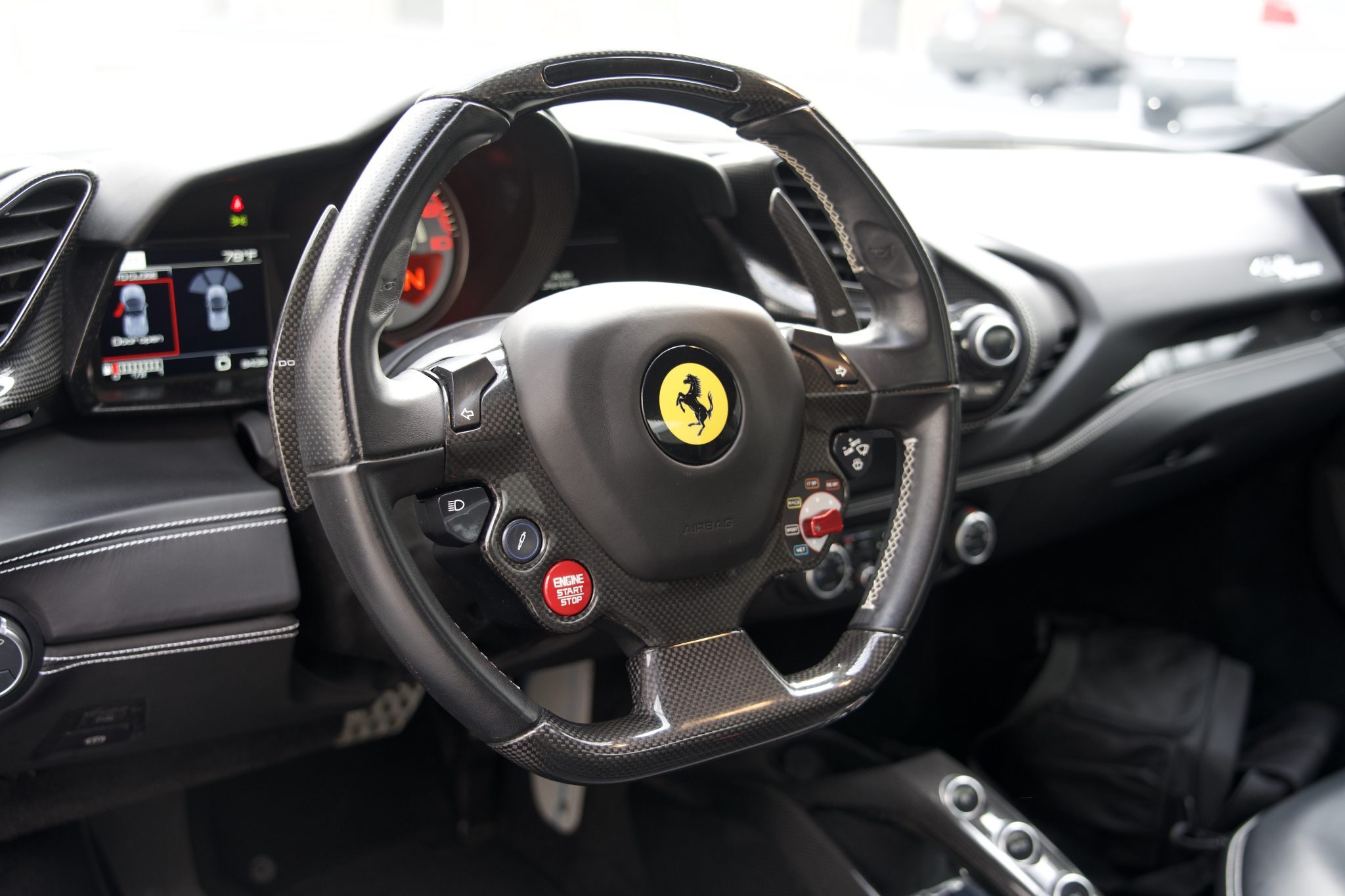Close-up of the Ferrari 488 Spider steering wheel, featuring advanced controls for rentals in Houston.