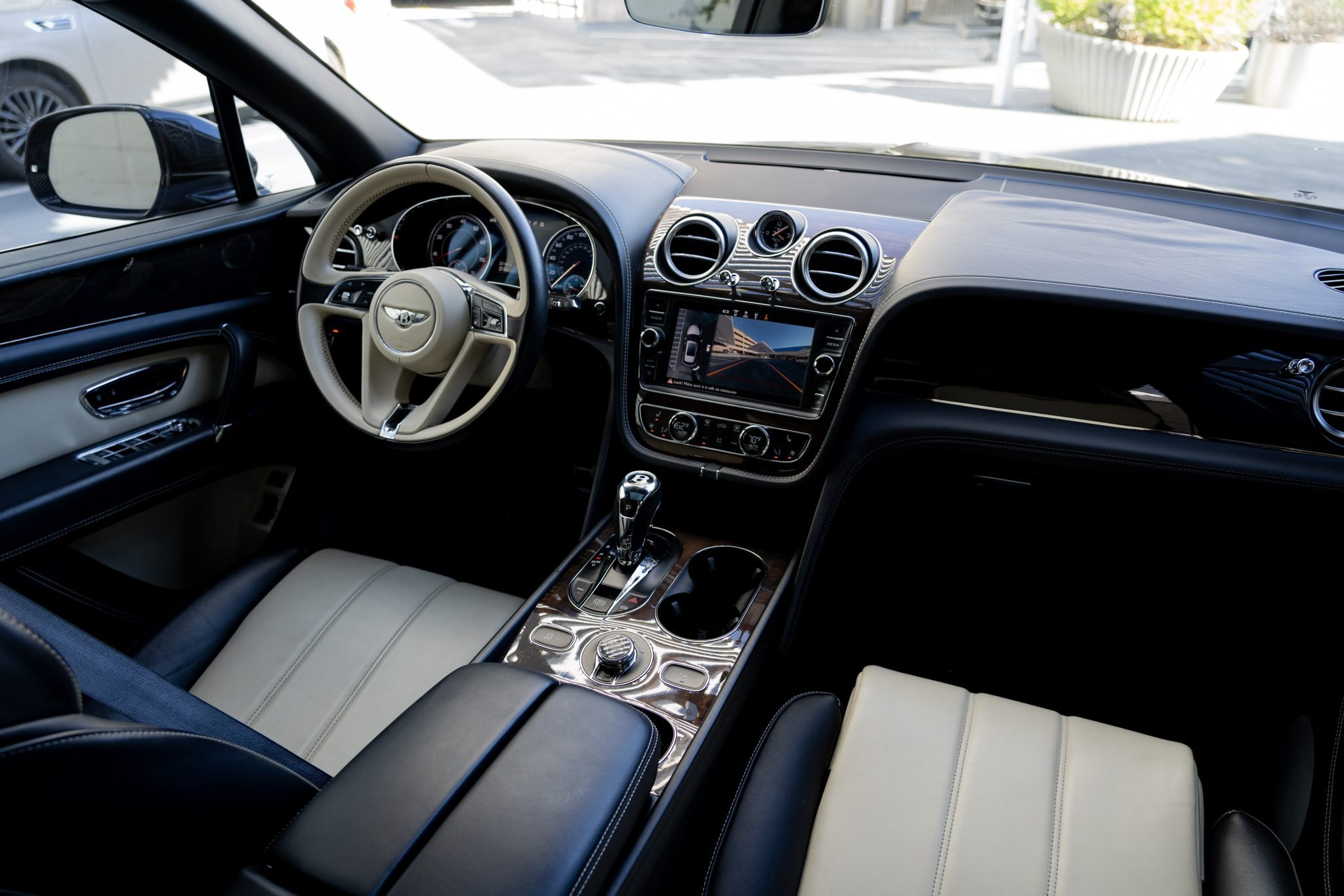 Bentley Bentayga interior with luxury leather seats and digital dashboard.