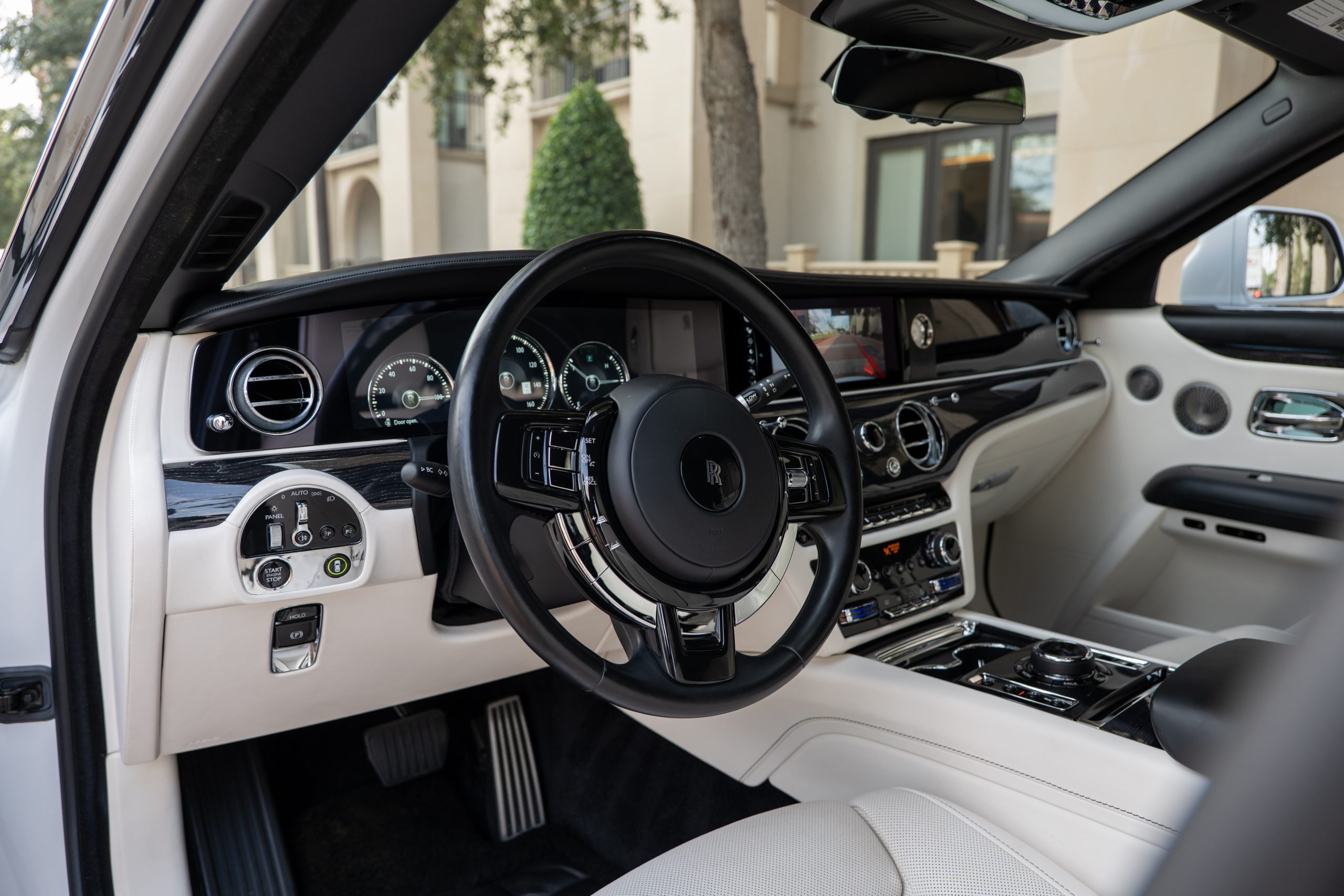 Rolls Royce Ghost steering wheel and central console with leather, brushed metals, and touchscreen interface.