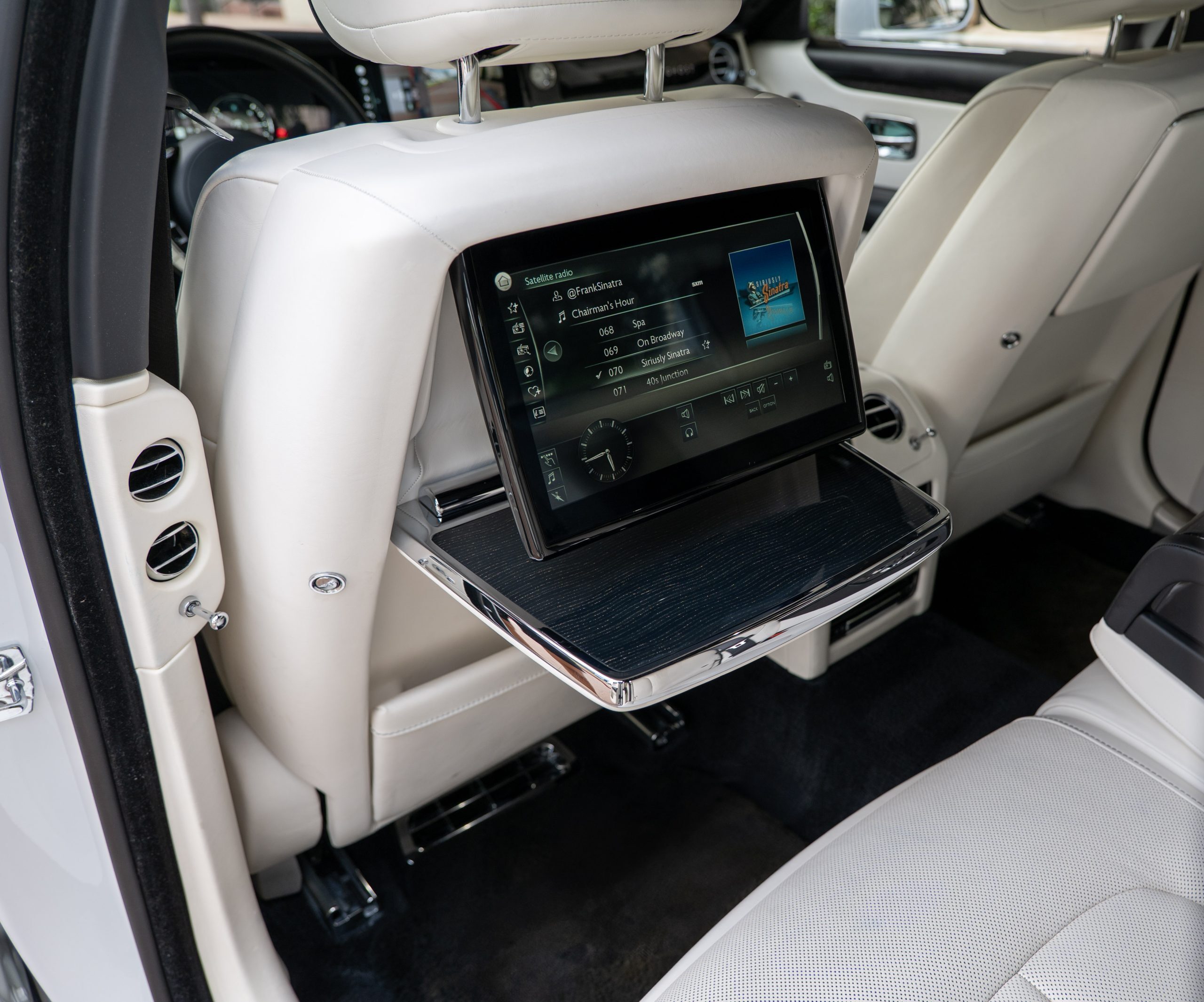 Rolls Royce Ghost white leather rear seat, fold-out tray, and rear-seat entertainment touchscreen display.