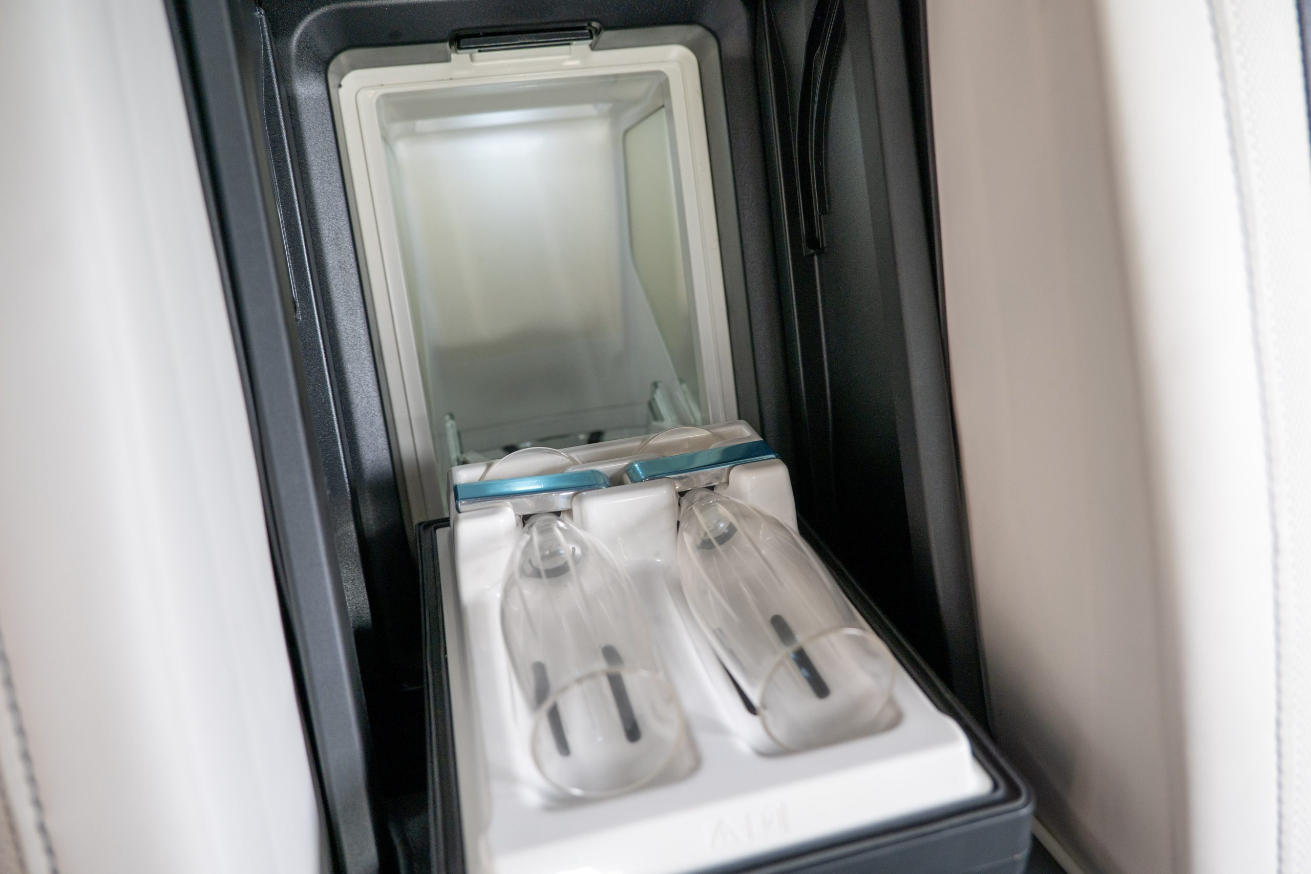 Rolls Royce Ghost rear seat armrest with integrated illuminated champagne cooler and crystal glass holder.