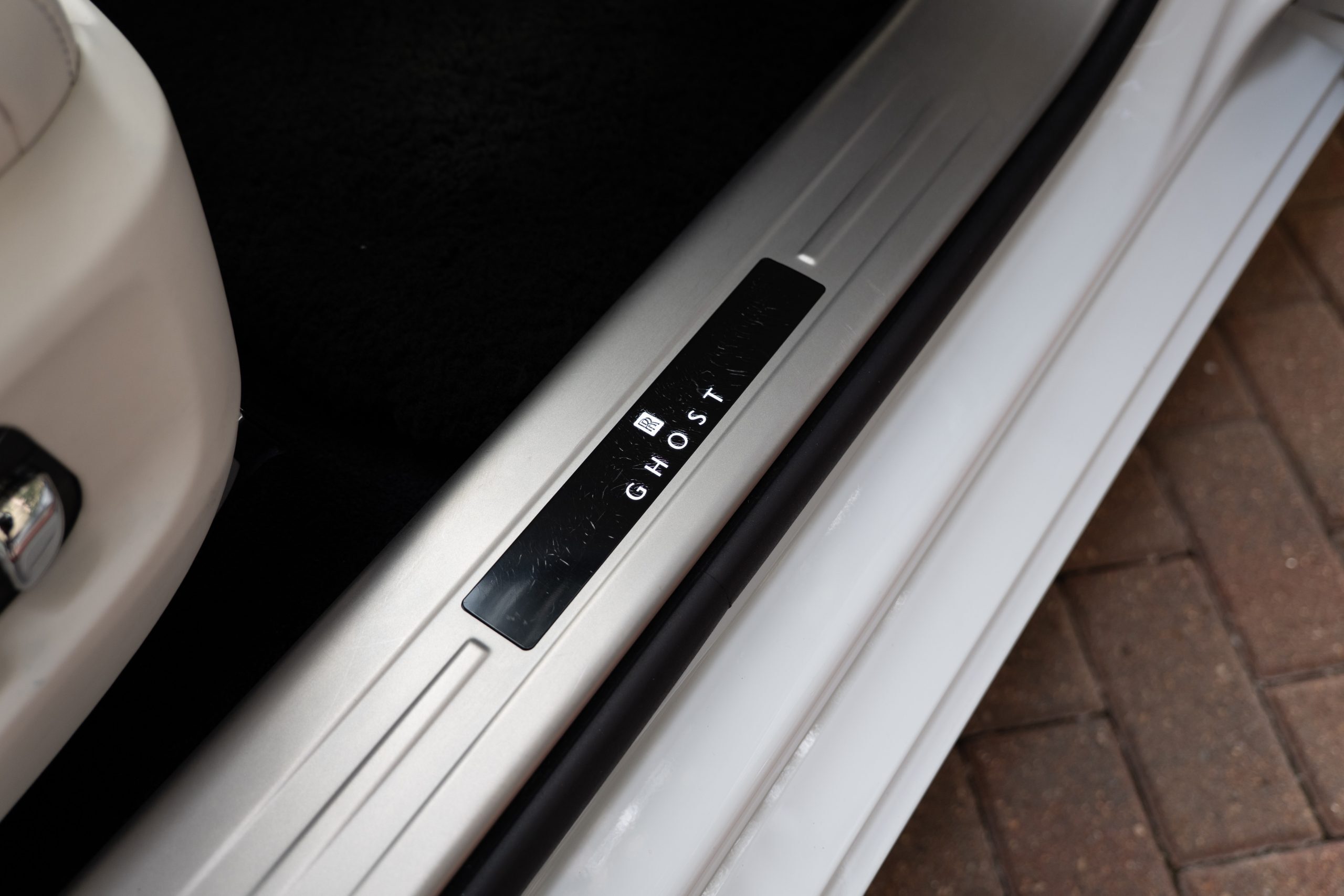 Rolls Royce Ghost illuminated door sill plate with RR logo, “GHOST” branding, and brushed aluminum trim.