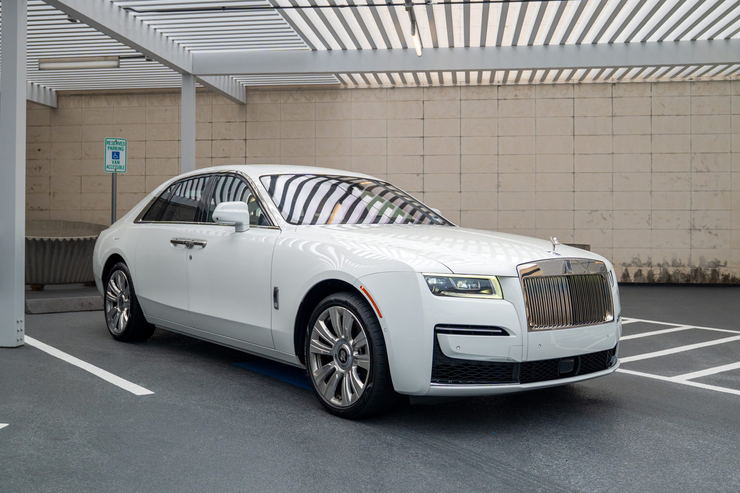White Rolls Royce Ghost parked in a covered Houston location, showcasing its chrome grille and luxury presence for Houston Rental services.