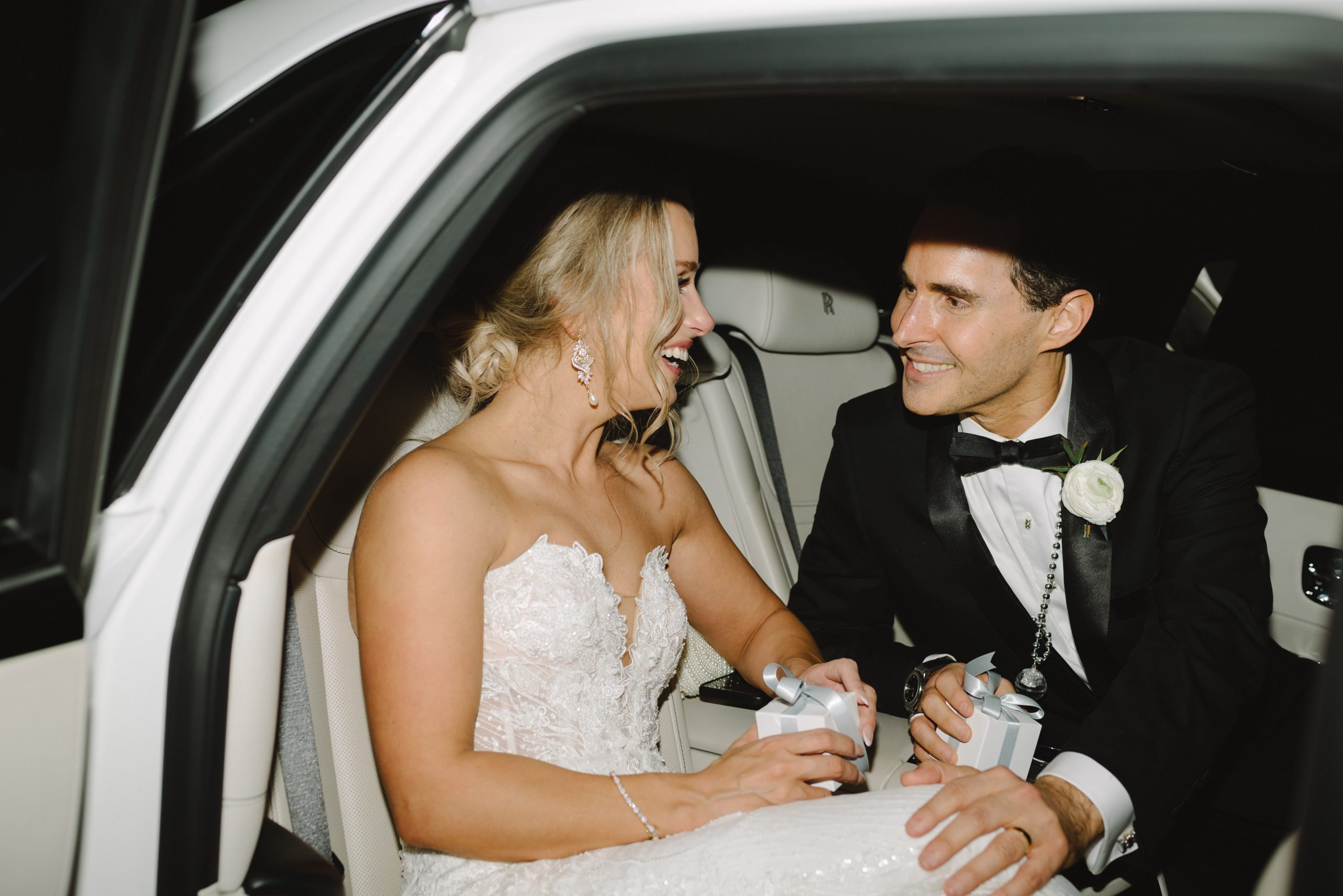 Couple celebrating in the back seat of a Rolls Royce Ghost wedding car rental in Houston