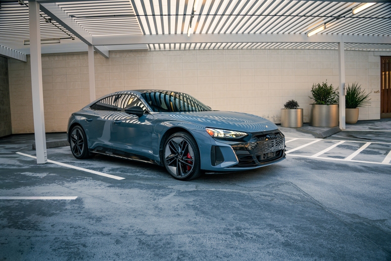 Gray Audi e-tron GT parked in a modern covered parking area in Houston